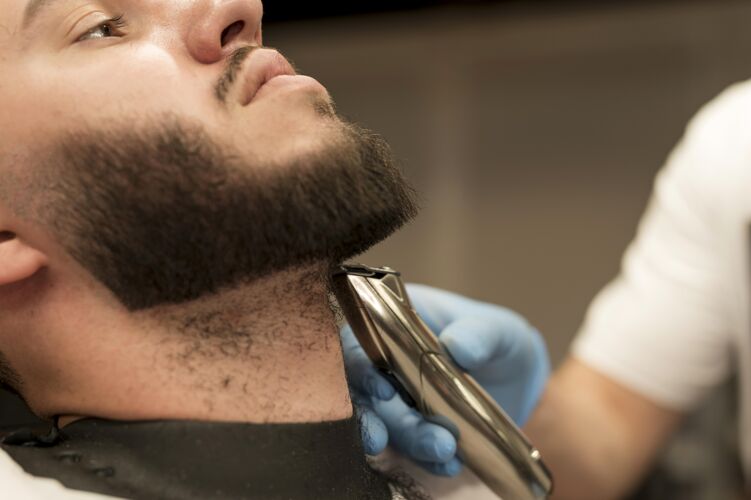 修剪在理发店理胡子的年轻人男人就业雇员
