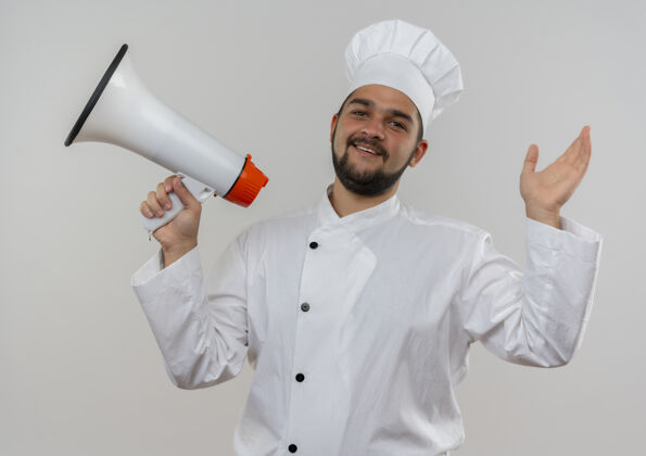 抱着快乐的年轻男厨师身着厨师制服 手持扬声器 举手孤立地站在白墙上厨师男性提高