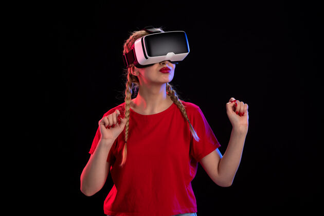 成人年轻女性在黑暗的墙上玩虚拟现实的正面图正面女士人物