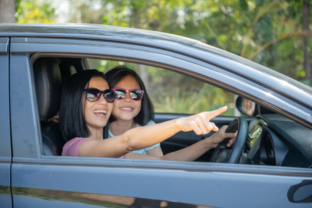 自由一家人放假 一家人开着自己的车在公路上旅行 妈妈开车 女儿坐在旁边 妈妈和女儿在旅游夏天坐汽车父母乐趣司机