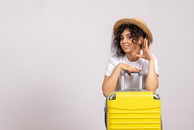 飞行正面图年轻女性带着黄色的包准备在白色背景上旅行太阳色航行飞机休息旅游飞行度假休息封面女郎人