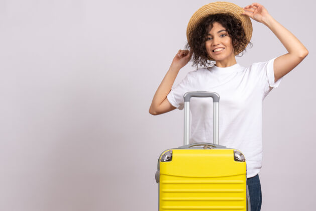 美丽正面图年轻女性带着黄色的包准备在白色背景上旅行旅游度假航班飞机航行彩色休息航行旅行微笑