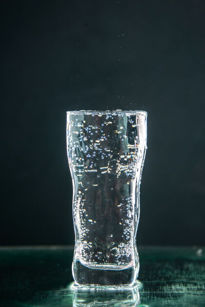 水前视图一杯苏打水在黑暗中喝满照片香槟圣诞水容器正面液体