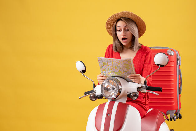 地图骑着轻便摩托车的漂亮女孩拿着红色的手提箱人车辆摩托车