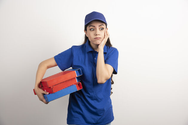盒子年轻的女信使拿着一纸板披萨和剪贴板女人披萨工人