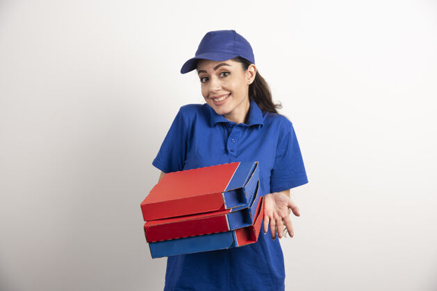 人年轻的女信使拿着一纸板披萨和剪贴板女孩披萨帽子