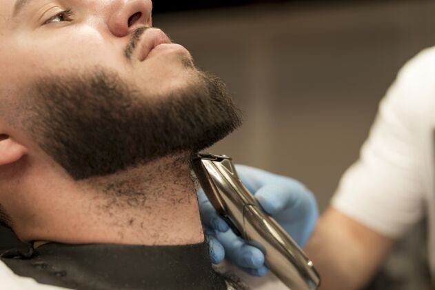 修剪在理发店理胡子的年轻人男人就业雇员