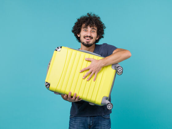 男性度假的男人拿着蓝色的大黄色手提箱包休闲大