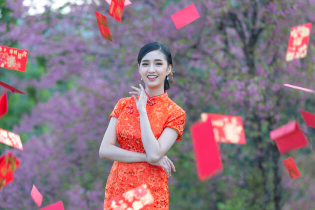 女性美丽的亚洲女人在中国的新年里展示一些东西和拿红包问候语年轻女人
