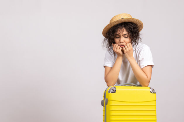 航行正面图年轻女性带着黄色的包准备乘坐白色背景色的旅行度假飞机太阳休息旅游航班人旅行休息
