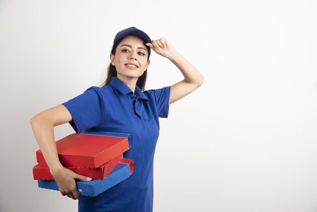 商业身着蓝色制服的快乐微笑送货女孩 白色背景上有外卖披萨盒高质量照片包装送货女性