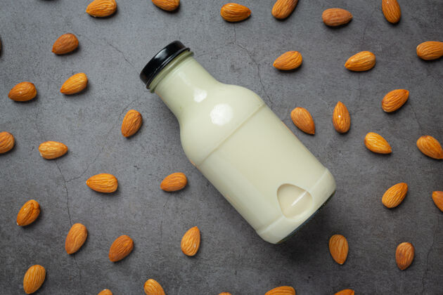 木头杏仁牛奶在瓶子里 杏仁在深色的背景上奶制品饮食特写