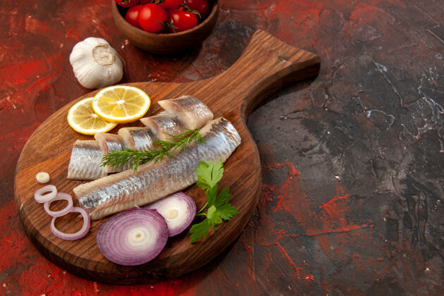 大蒜正面图：新鲜的鱼片 洋葱圈和西红柿 深色小吃 肉色海鲜膳食新鲜番茄