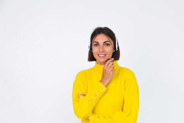 帮助热线穿黄色毛衣的漂亮女人戴着白色经理的耳机开心的积极的欢迎微笑建议社交服务