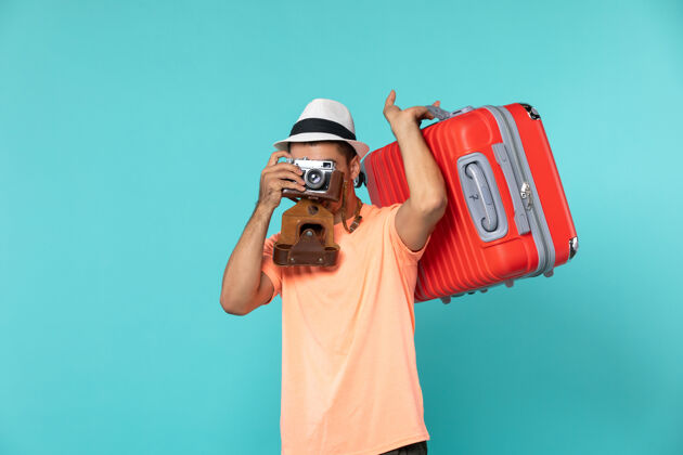 人带着红色手提箱和相机在蓝色上拍照的度假男人男人男性红色