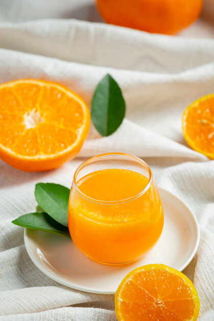 木头新鲜的橙汁在玻璃大理石背景上挤压冷柑橘