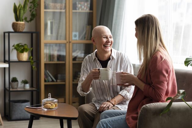 战斗患有皮肤癌的中年妇女和她的朋友在一起保健秃头意识