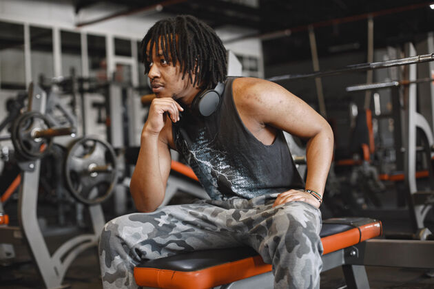 锻炼健身房里的运动男一个黑人在做运动一个穿黑色t恤的家伙设备非洲运动鞋