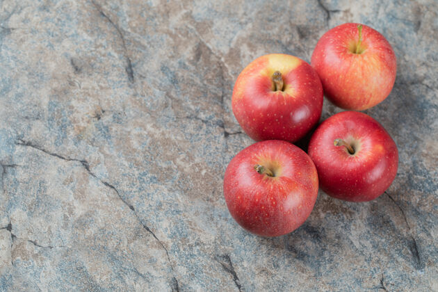 热带红苹果孤立在灰色大理石上顶视图水果酸