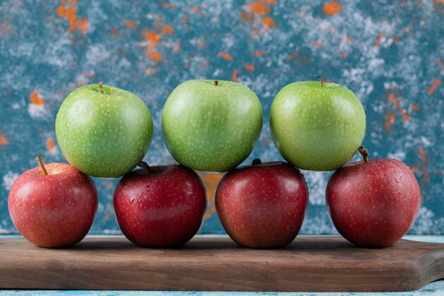 食物红苹果和绿苹果被隔离在木板上酸示范水果
