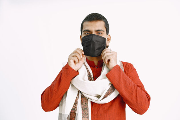 检疫一个印度男人戴上医用口罩 一个穿着橙色衬衫和围巾的男人展示如何戴上医用口罩成人衬衫印度人