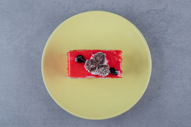 派黄色盘子上新鲜自制蛋糕片的俯视图美味卷发蛋糕