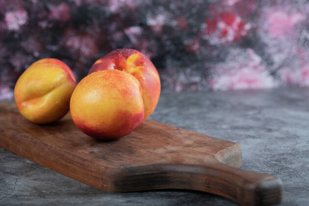 酸桌上木板上有红黄相间的桃子产品热带美味