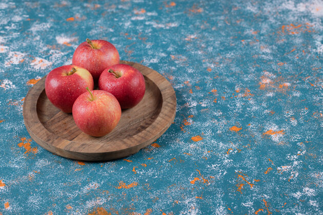 产品红苹果放在蓝色的木盘上水果异国情调板材