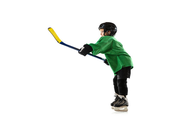 年轻冰球场上的小冰球手 白色的工作室墙动作棍棒头盔