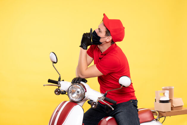 工作正面图：穿着红色制服 戴着黄色面具的男信使制服传送带自行车
