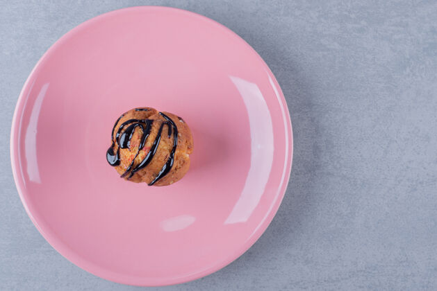 折叠自制香蕉焦糖松饼放在粉红色盘子里饼干餐特写