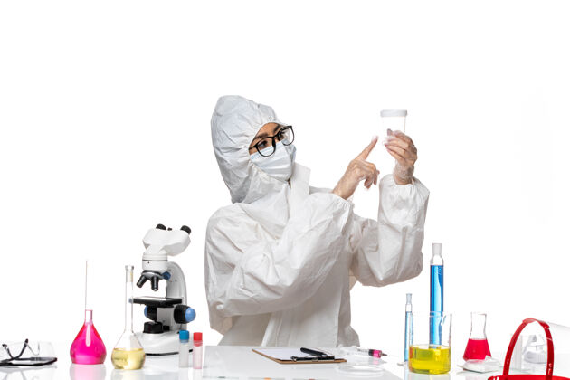 持有正面图身着特殊防护服的年轻女化学家手持浅白色背景的空烧瓶实验室病毒-化学病毒健康实验室空医生