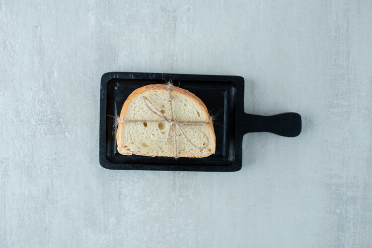 面包房白面包用绳子绑在黑木板上吐司白面包木材