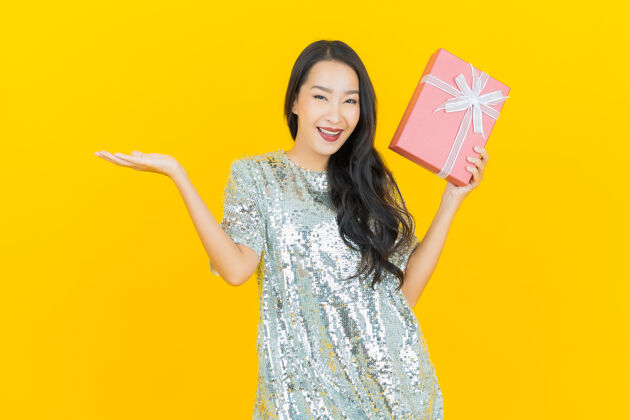 亚洲肖像美丽的亚洲年轻女子微笑红色礼盒上的黄色礼盒年轻帽子