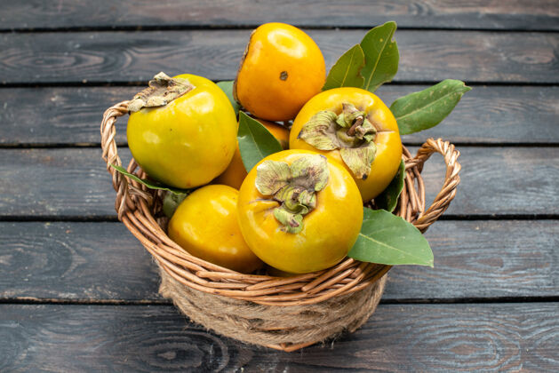 食品正面是新鲜的柿子成熟甜美的水果放在木桌上成熟的水果醇厚的树木材树木水果