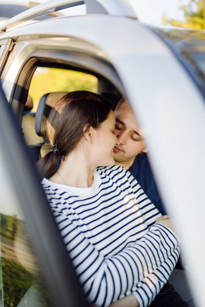 情人在车里微笑的年轻夫妇在车里接吻车车辆司机