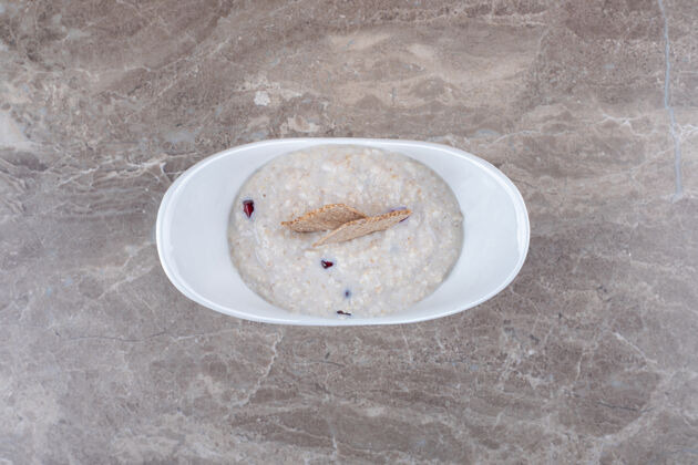 味美石榴皮放在粥里的盘子里 放在大理石的表面风味燕麦八角