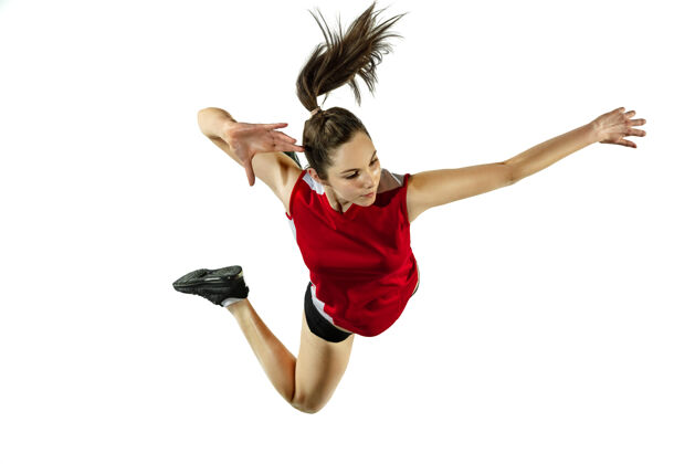 健身在跳跃和飞行中年轻的女排运动员被隔离在白色的工作室背景下穿着运动服和运动鞋的女子训练 比赛运动的概念 健康的生活方式 运动和运动肌肉训练运动员