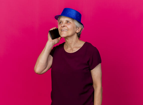 派对戴着派对帽的老太太高兴地在电话上说粉红话女人帽子拜托