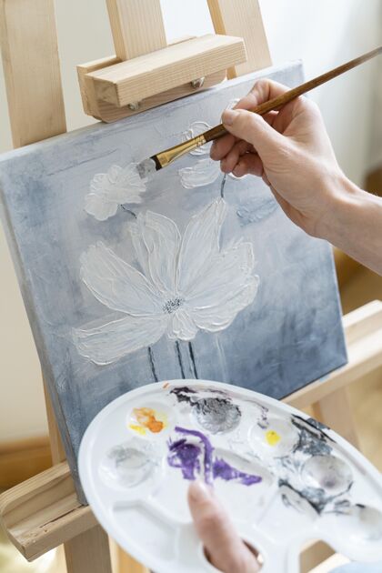 和平高角度的女性手画一朵花在家里调色板艺术家室内活动