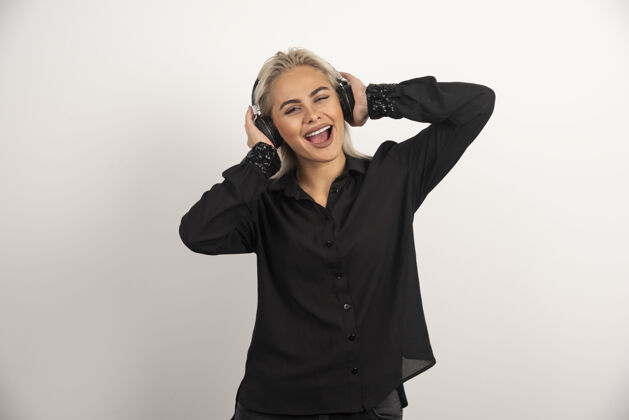 成人金发女人用耳机在白色背景上听歌曲高质量的照片女人音乐肖像