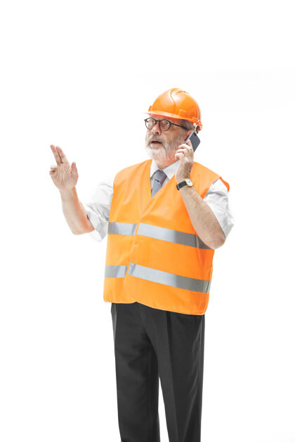人员一个穿着建筑背心 戴着橙色头盔的建筑工人在用手机谈论着什么业务人员建筑专业人员