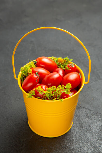 桶底部是一桶樱桃番茄和莳萝花的深色背景浆果容器容器