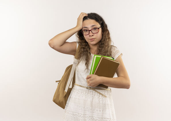 表情体贴的年轻漂亮的女学生戴着眼镜 背着书包 手放在头上 隔离在白色的墙上人手包