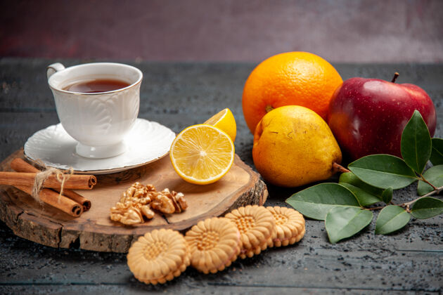 健康在黑暗的桌子上可以看到一杯茶 里面有水果和饼干可食用水果仪式深色