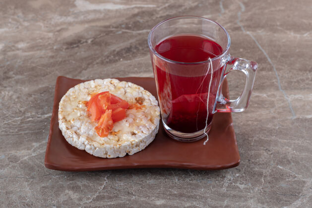 营养麦片粥用西红柿片放在一个玻璃木盘上 放在大理石表面风味美味可口