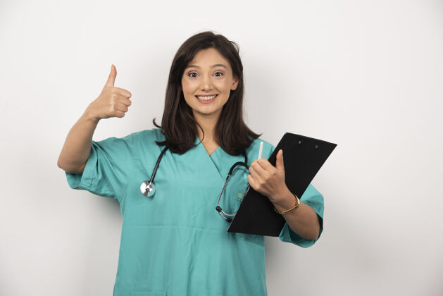 诊所带听诊器和剪贴板的女医生在白色背景上微笑高质量照片健康工作职业