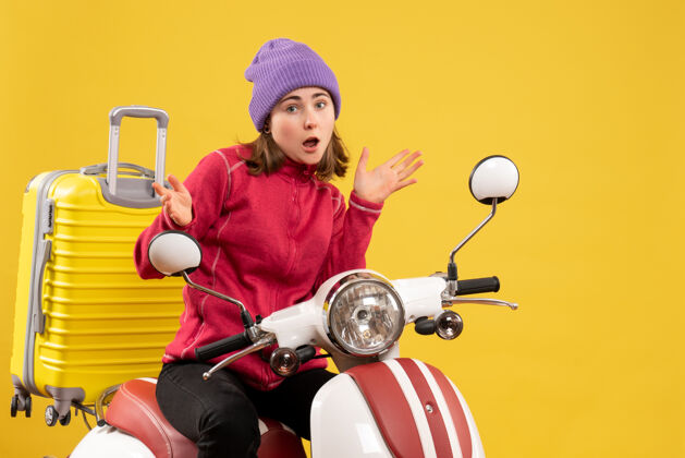 摩托车前视图：骑着轻便摩托车 戴着紫色帽子的年轻女孩轻便摩托车前面帽子
