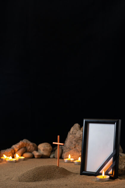 显示器空的相框上有石头 蜡烛和小坟墓在黑暗的表面笔记本电脑办公室黑暗