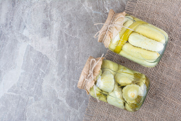 泡菜两罐各种腌菜放在粗麻布上麻袋小吃黄瓜